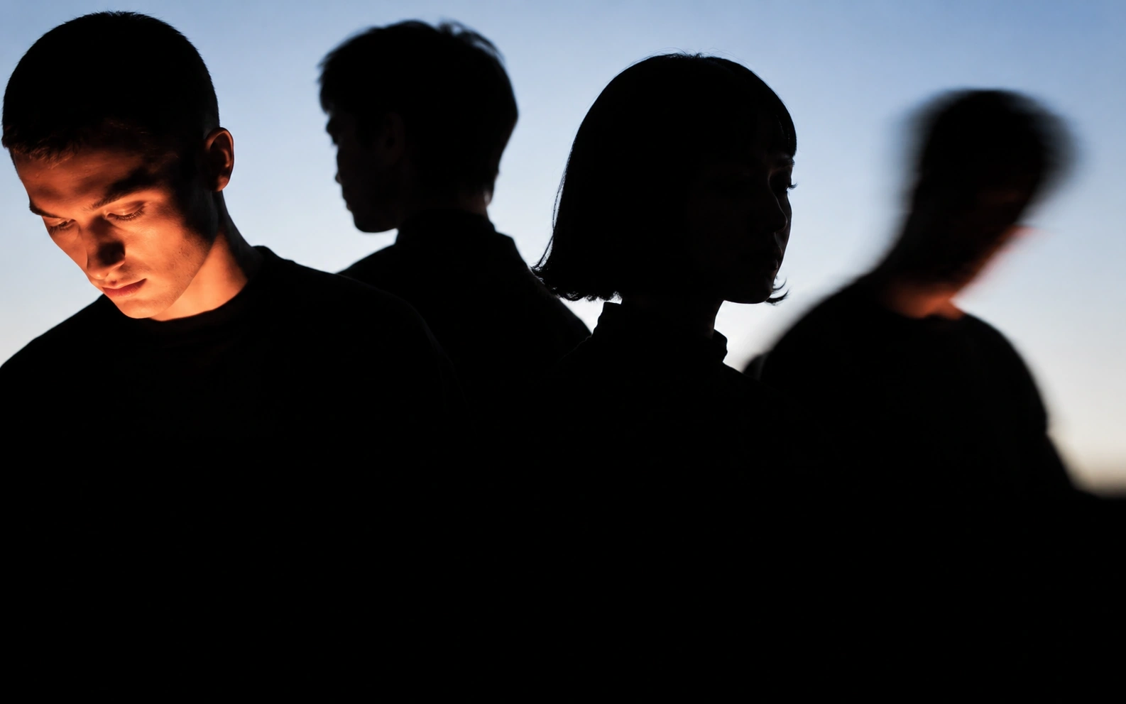 A diverse group of people standing together in dramatic light